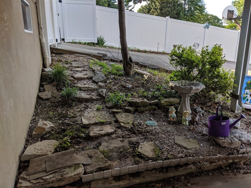 crumbling retainer wall behind a house
