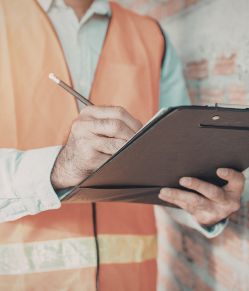 person with safety vest on holding a clipboard